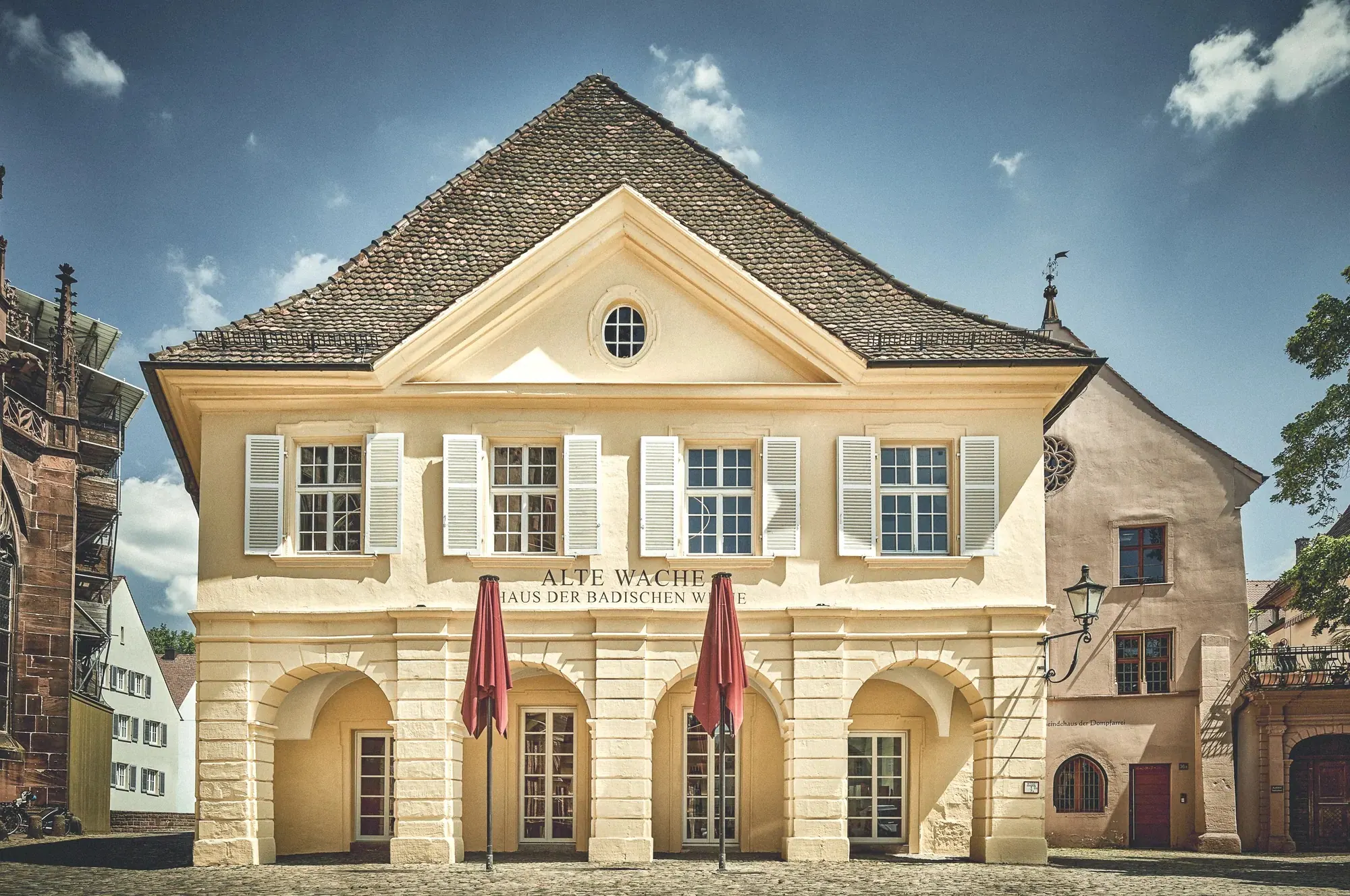 Alte Wache, Freiburg — Barockfassade mit Schriftzug „Haus der Badischen Weine“ bei Tag