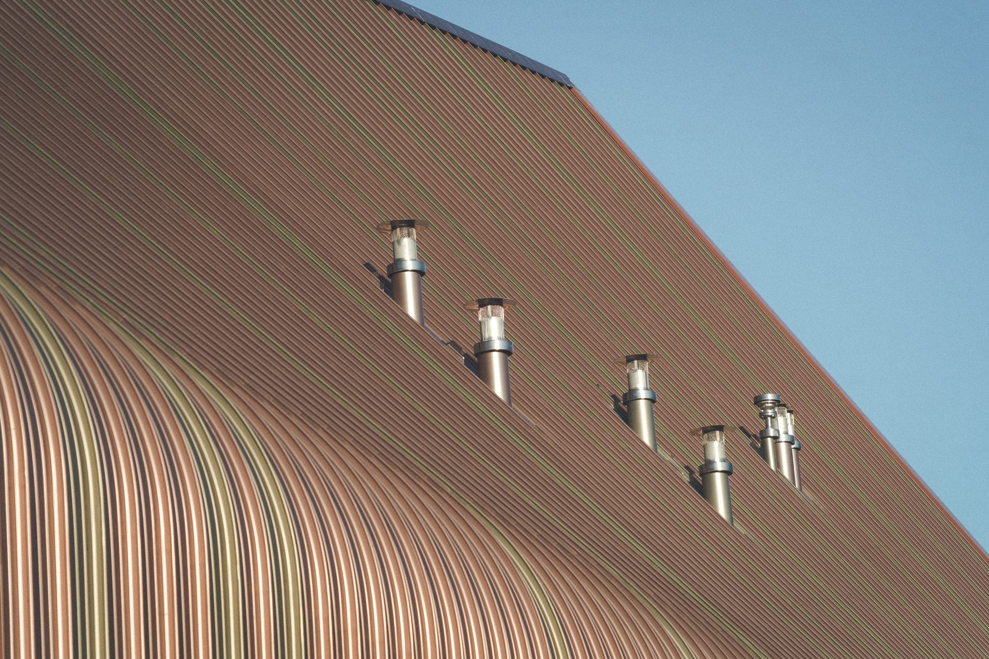 Ardgowan Distillery, Inverkip — Detail der Dachhaut aus Aluminium-Stehfalz, der Farbverlauf von Kupferrot nach Oliv mit den Entlüftern der Brennhalle