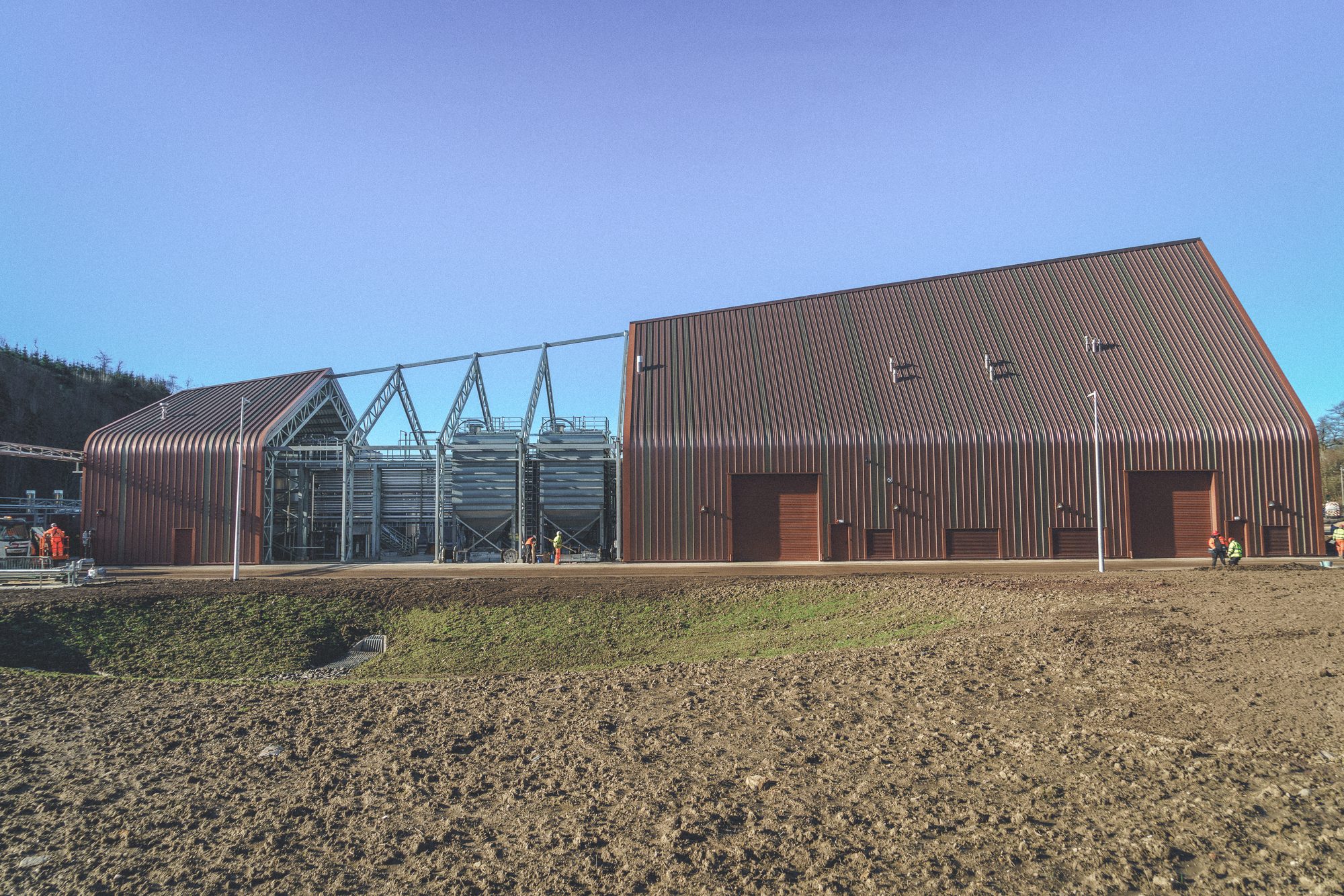 Ardgowan Distillery, Inverkip — die lange Halle und das offene Sudhaus kurz vor der Fertigstellung, Stahlgerüst und Malzsilos unter blauem Himmel