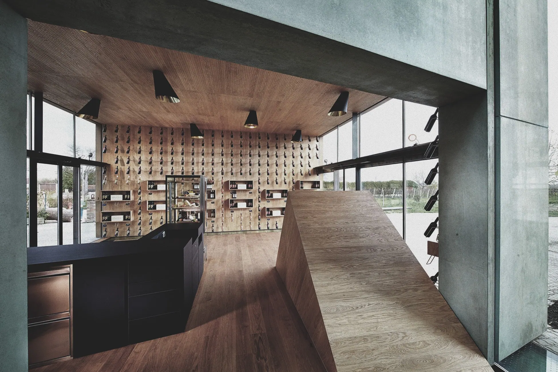 Bio-Weingut Frühwirth, Thermenregion — Verkaufsraum mit Flaschenwand, Theke und Holzdecke
