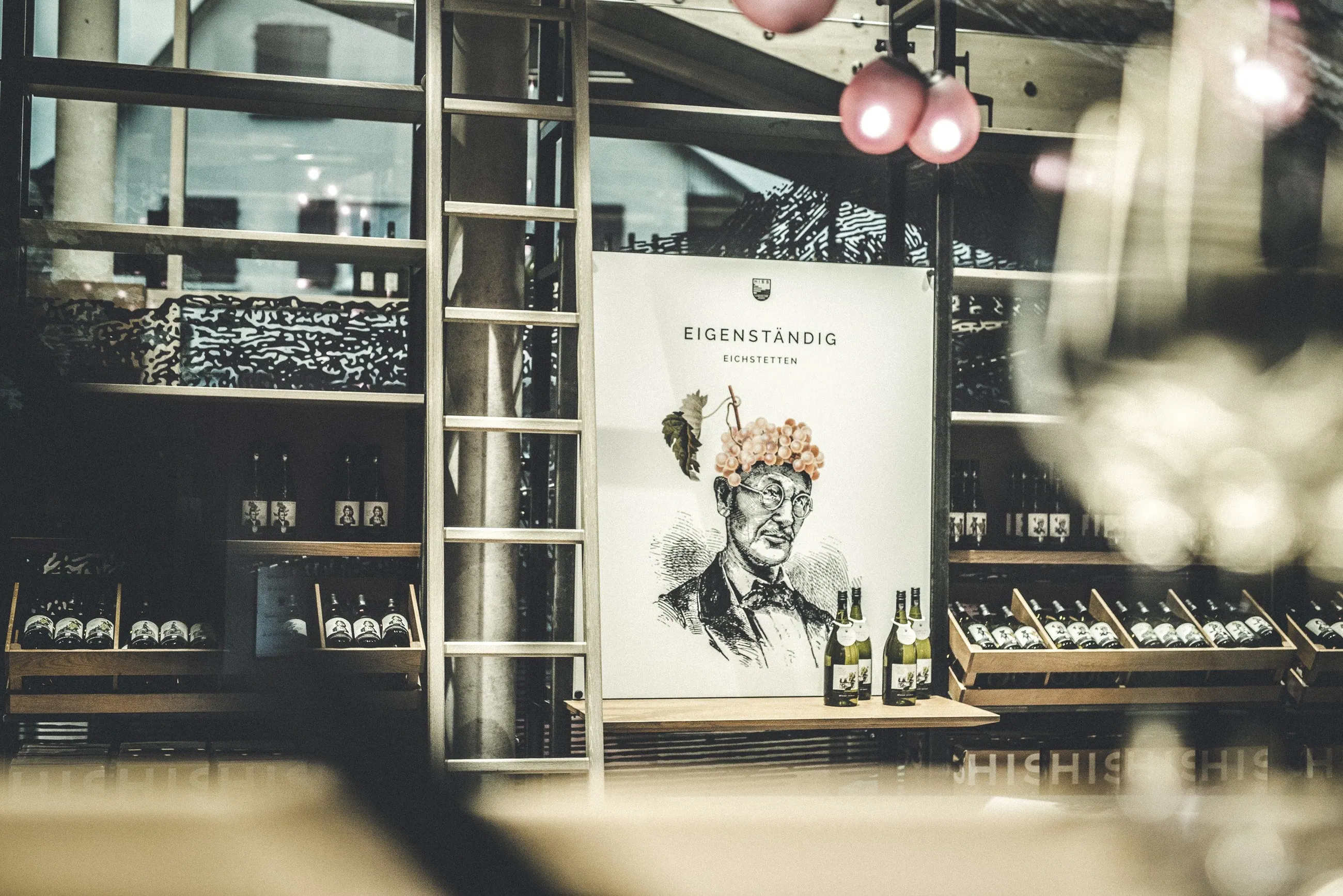 Weingut Hiss, Kaiserstuhl — Plakat der Linie Eigenständig zwischen Weinregalen im Verkaufsraum
