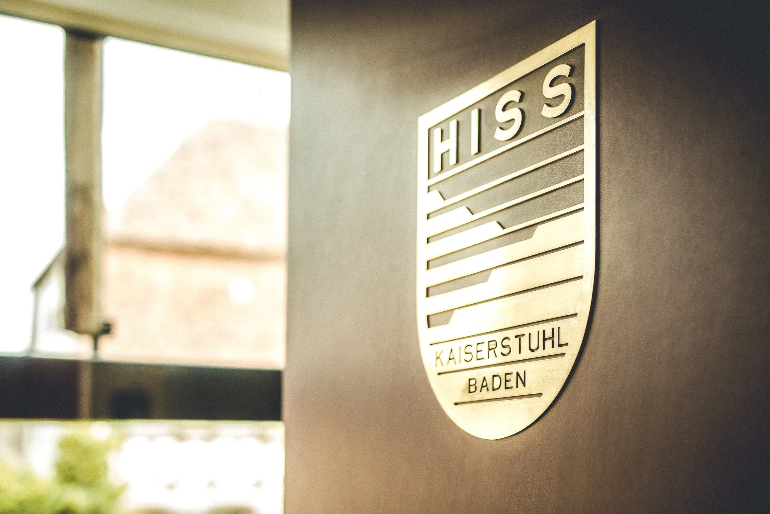 Weingut Hiss, Kaiserstuhl — das Wappen Hiss Kaiserstuhl Baden in Messing an der Wand
