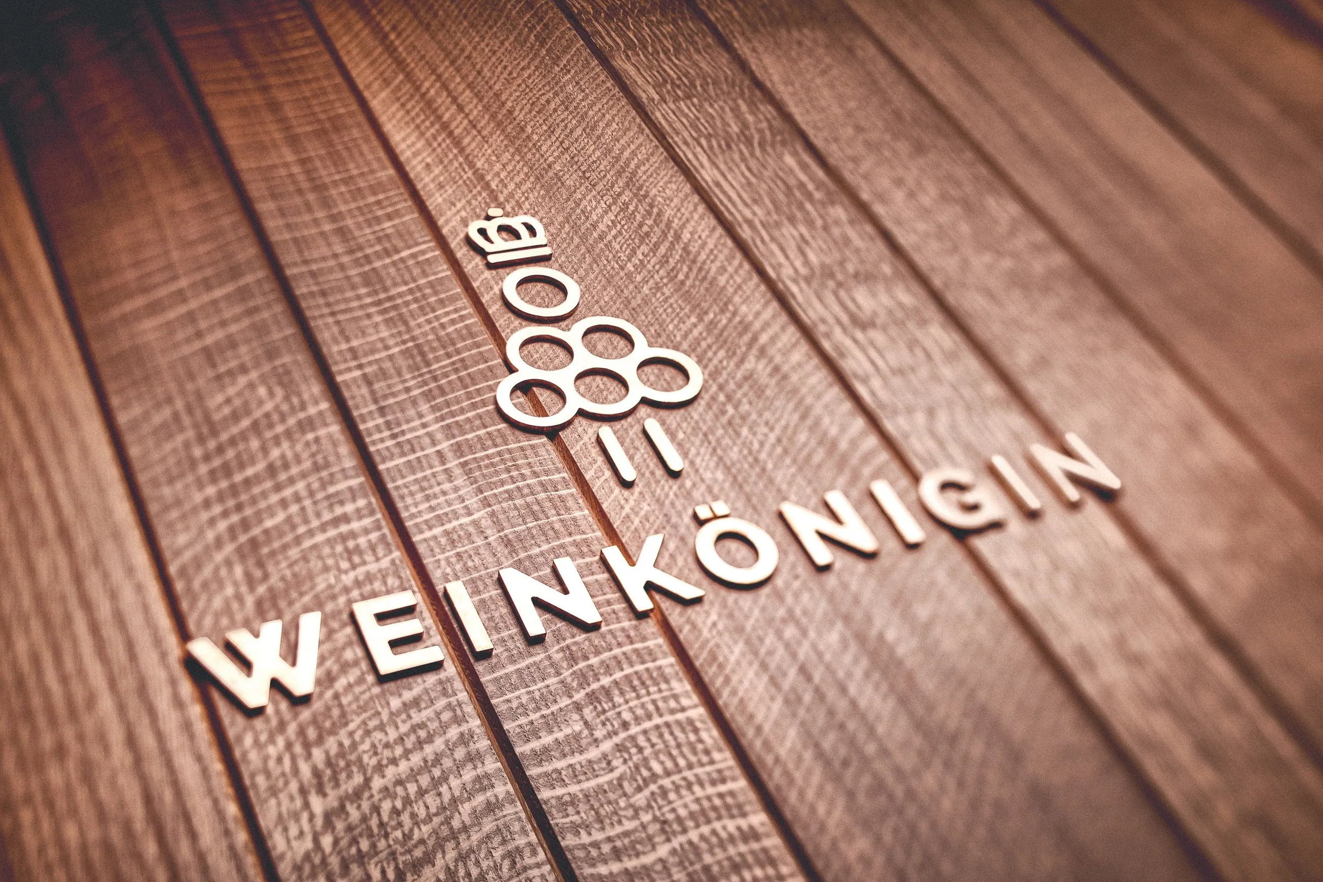 Weingut Hiss, Kaiserstuhl — Schriftzug Weinkönigin in Messing auf Eichenholz