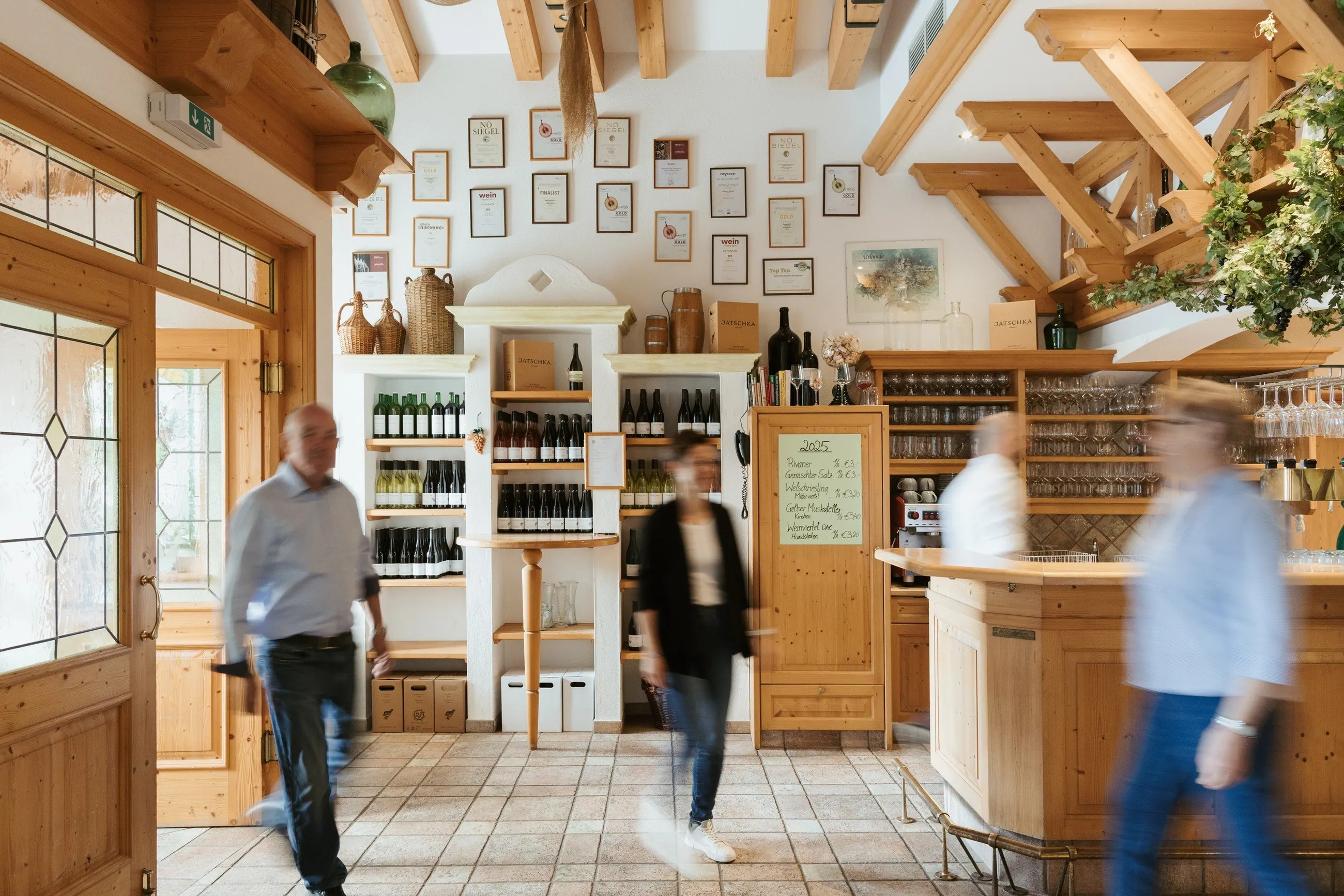 Weingut Jatschka, Weinviertel — Gäste im Verkaufsraum zwischen Weinregalen und Theke