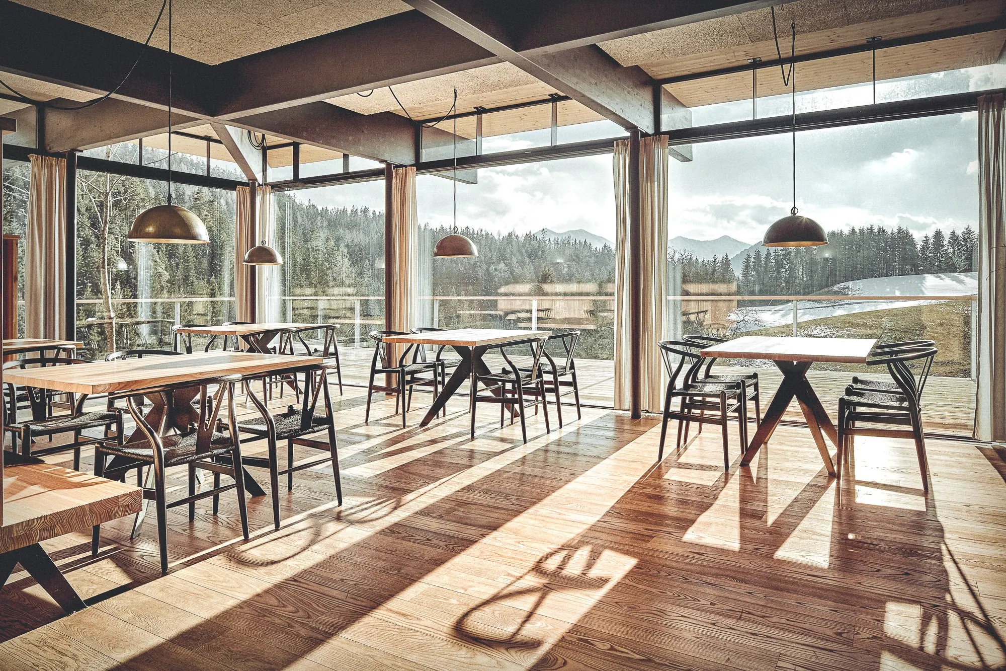 Restaurant Lurgbauer, Steiermark — Gastraum mit Holzbalkendecke und Panoramafenstern zur Landschaft