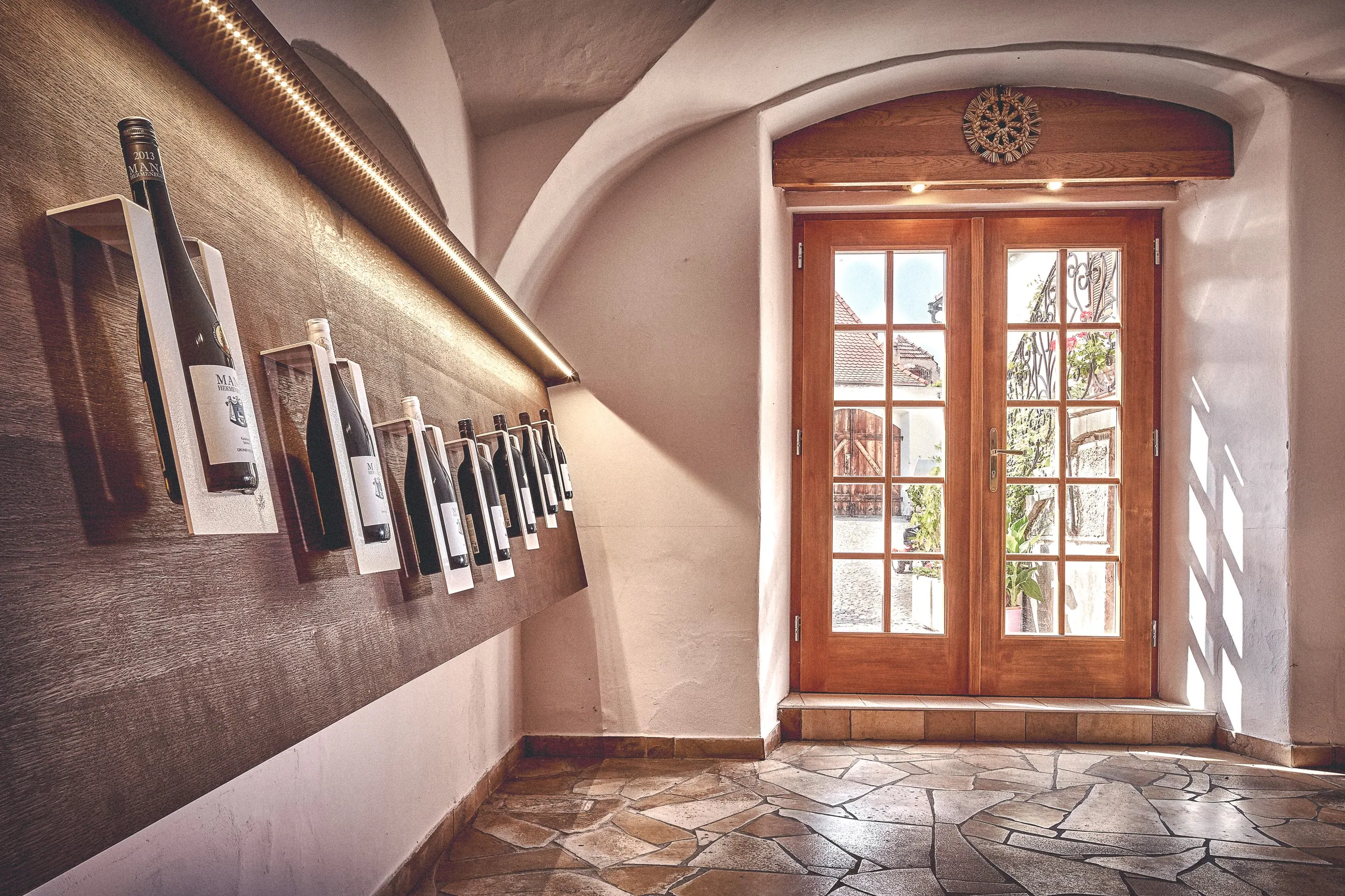 Weingut Mang, Wachau — Gewölbegang mit Flaschenschiene und Fenster zum Hof