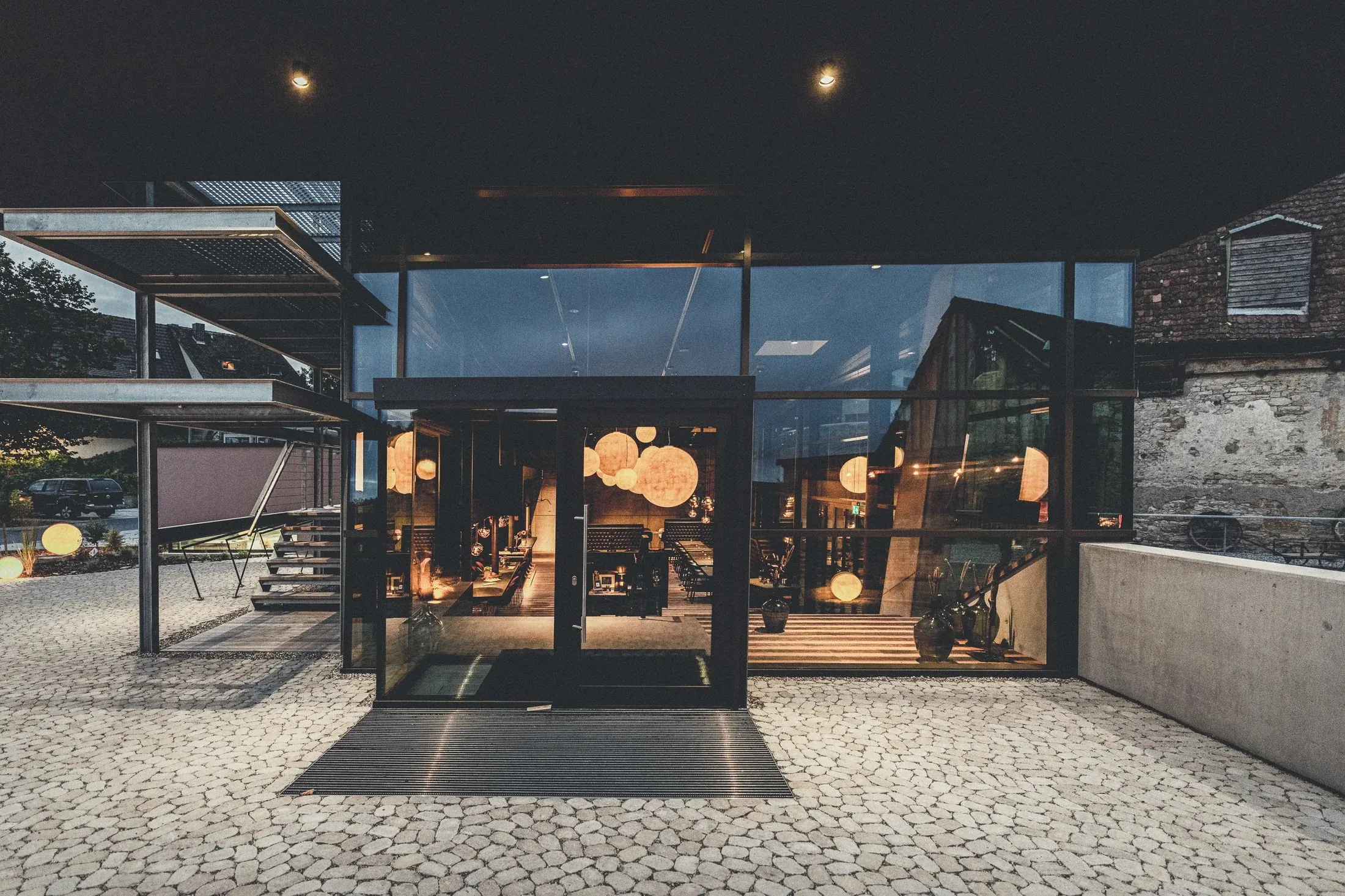 Schüler · Genussspielhaus, Baden — beleuchteter Eingang bei Nacht mit Blick in den Gastraum