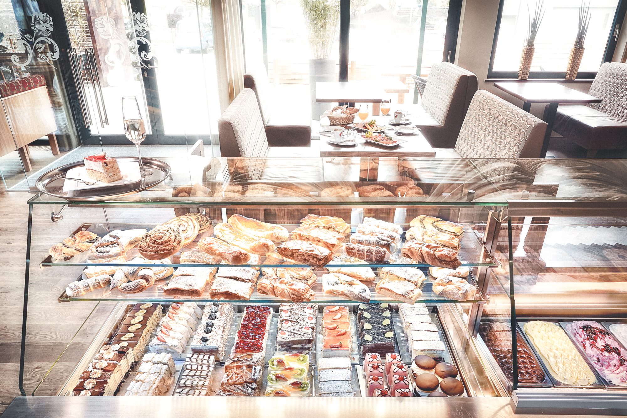 Restaurant Steiner, Pinsdorf — Vitrine mit Mehlspeisen und Eis, dahinter die Frühstücksnischen