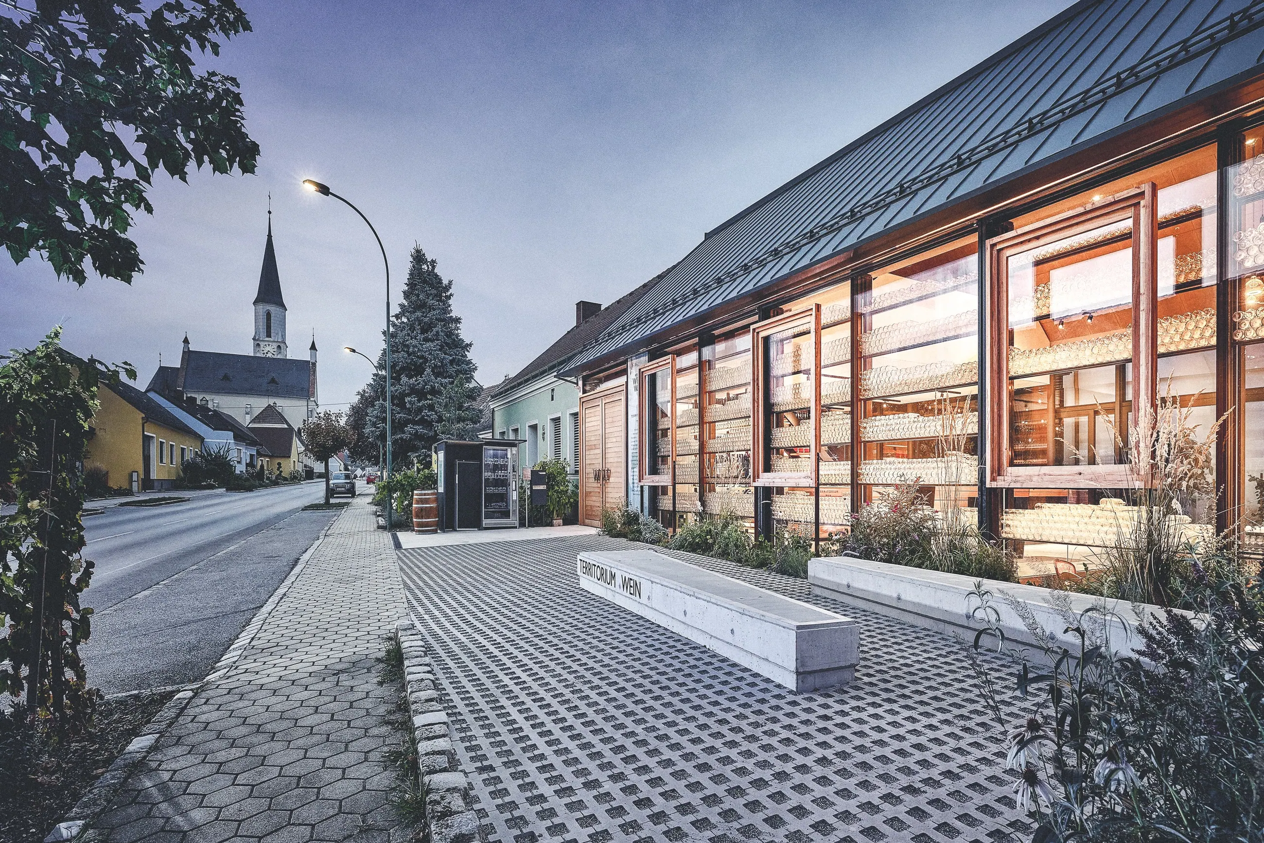 Weinwurm, Weinviertel — Strassenansicht in der Dämmerung, dahinter der Kirchturm des Orts