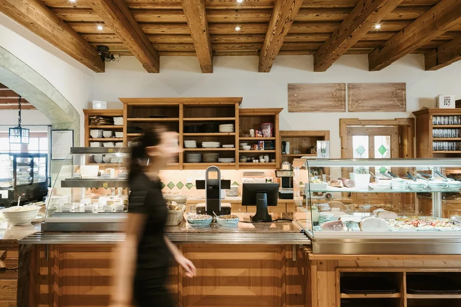 Weingut Leo Aumann, Thermenregion — Heurigenbuffet mit Speisenvitrine und Holzregal